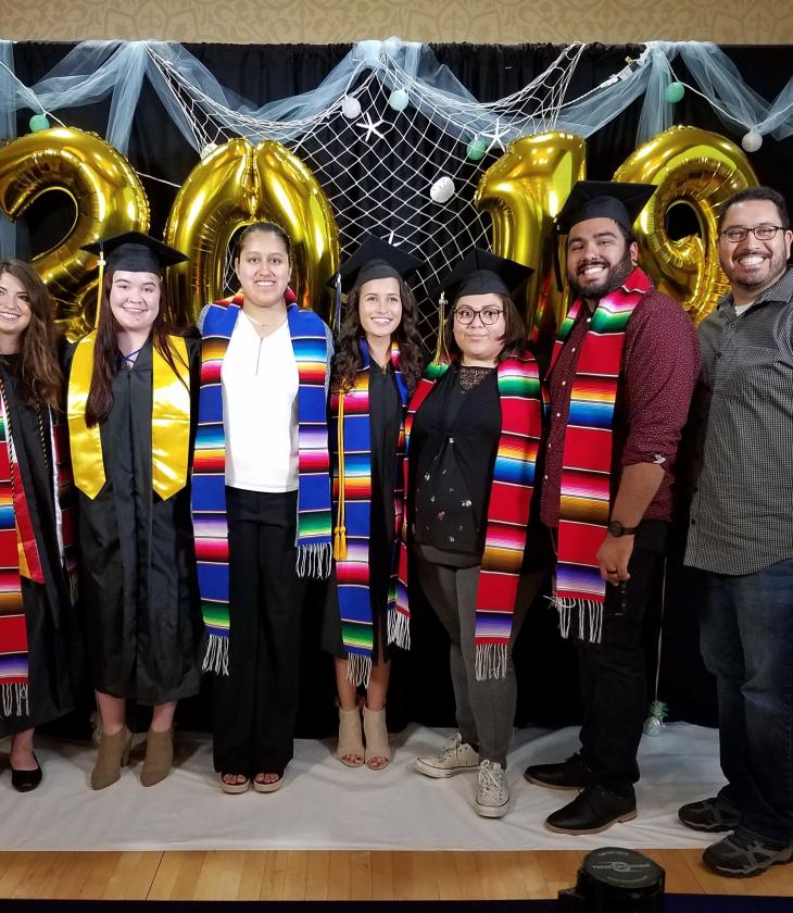 A group of graduates from the Latin American and Latinx Studies program pose in their colorful graduation attire.