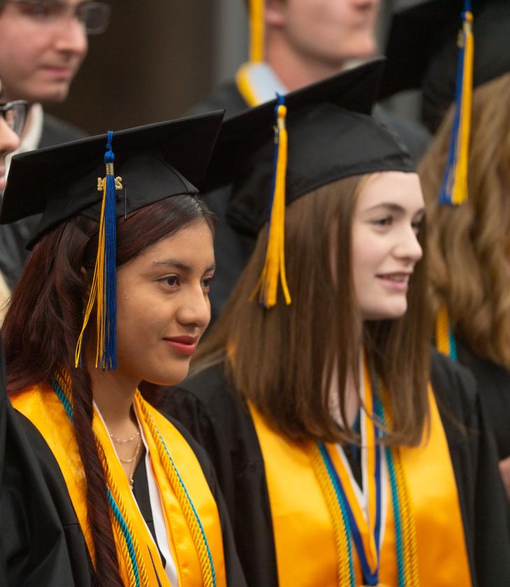 UWECBC students stand up during the Commencement ceremony.