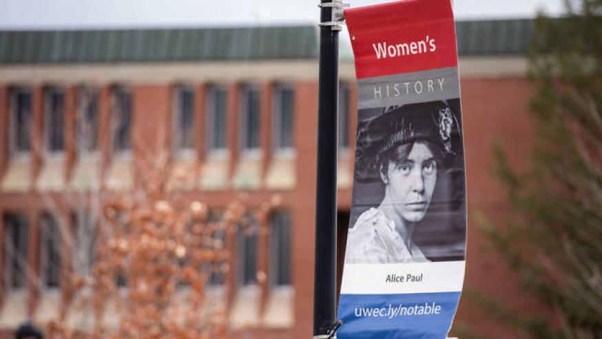 A women's history flag on a campus lightpole