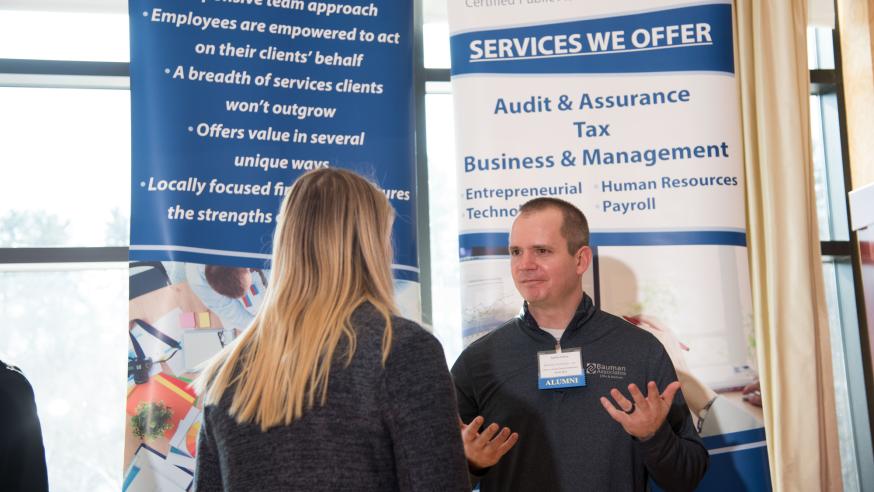 local accounting firm representative talking to a student at career conference