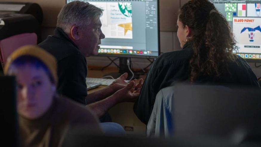 student and faculty in a graphic design classroom 