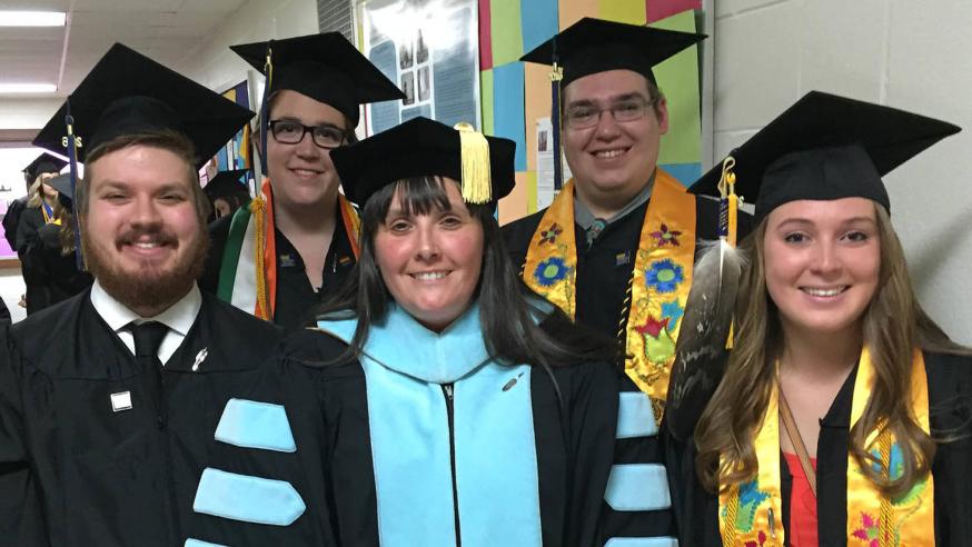 Heather Moody of AIS poses with AIS grads