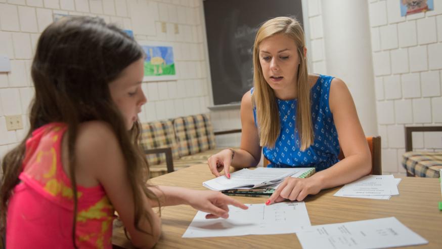 college student helping youth student in a tutoring session