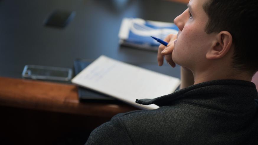student in class, notepad on table