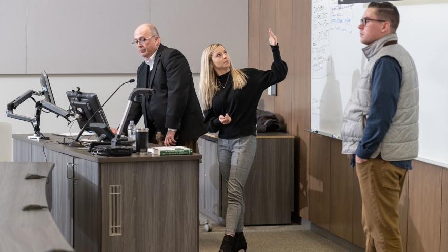 female student, COB faculty  and guest in classroom