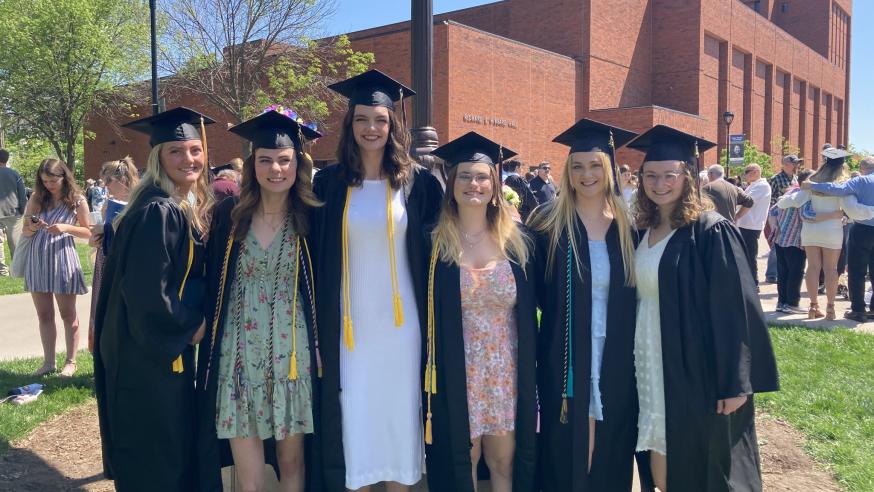 6 female sociology graduates outside in caps and gowns