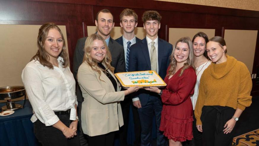 sales group at COB awards night with a cake