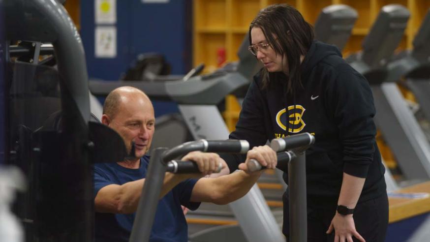 student working with client in workout class
