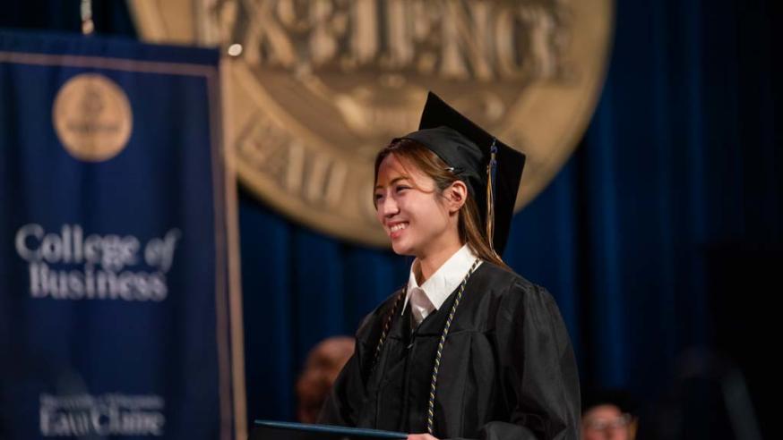 female graduate crossing the stage at commencement