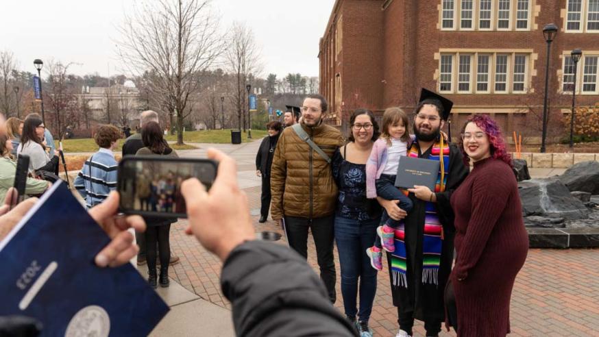 LatinX graduate outside Schofield with family
