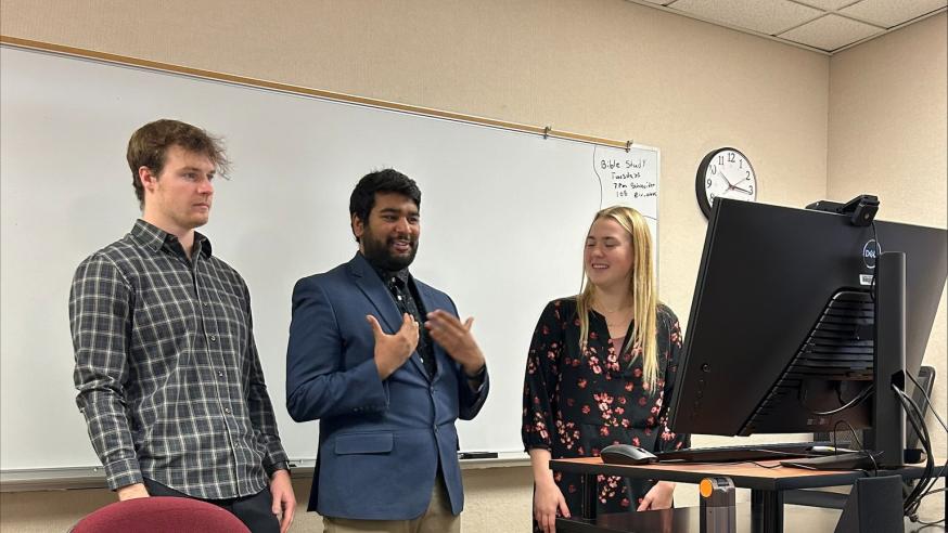 three students presenting in business classroom 