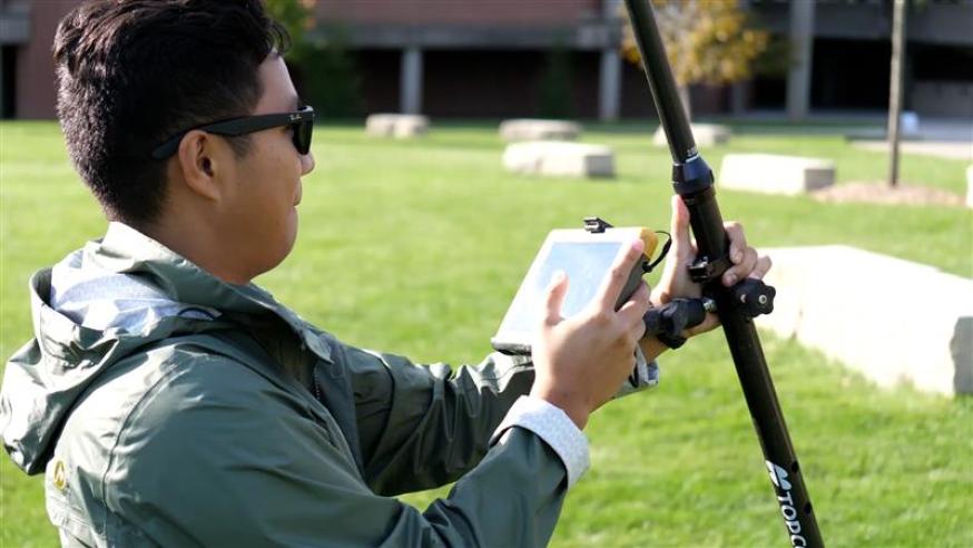 student using GIS device outside