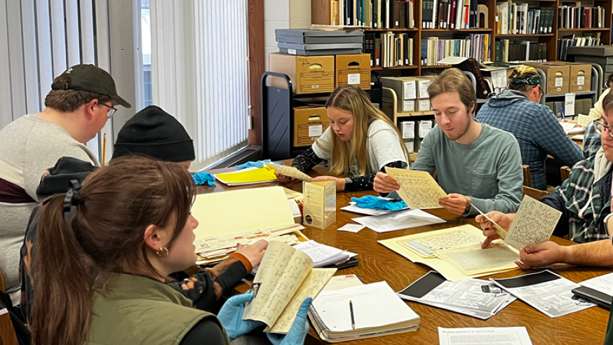 student sin the archives handling old documents