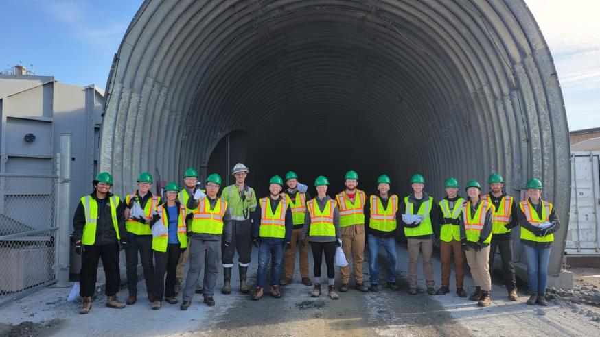 Geology student group at area mining site in protective gear 