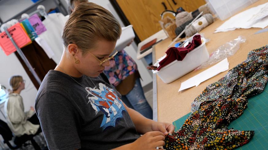 student sewing a garment in costume shop for theatre arts 