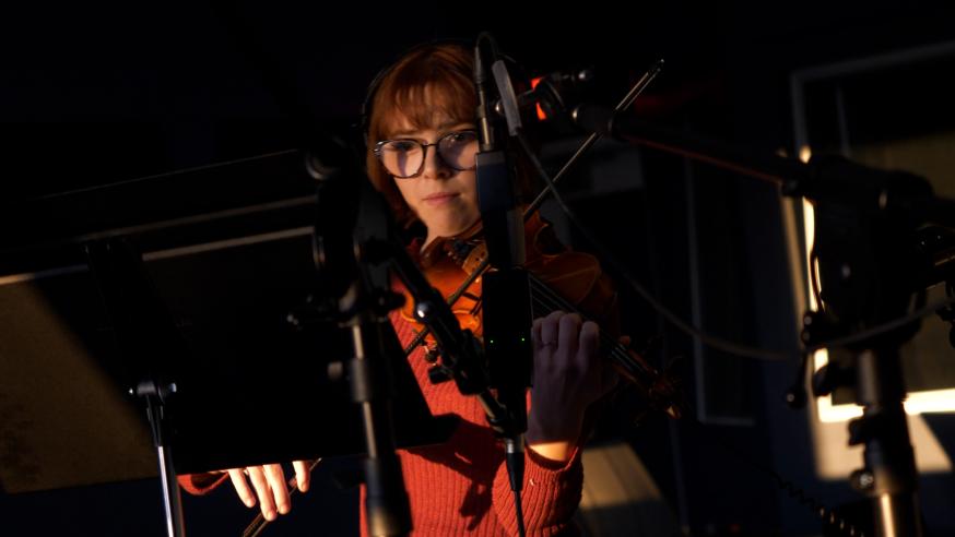 student in recording studio playing violin