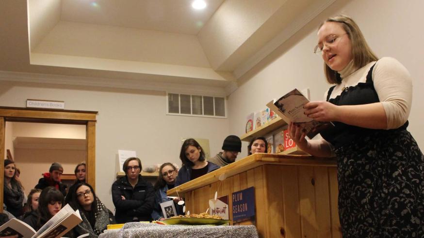 female English student at a podium with a book