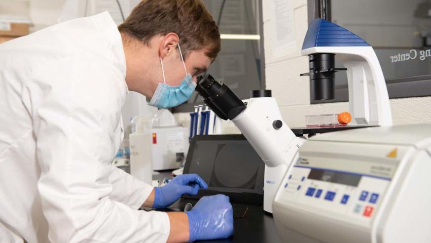 student at a microscope in MSE center