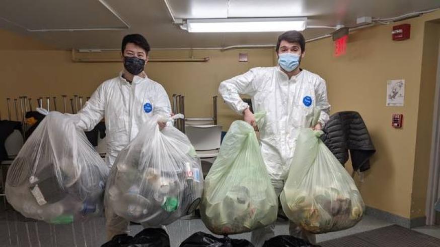 students holding trash bags for waste study on campus 