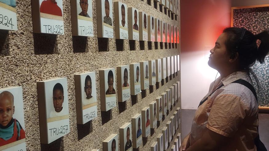 France immersion for Hmong studies, student looking at photo memorial wall