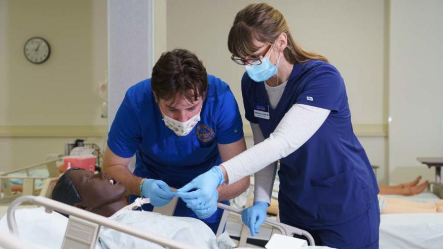 two nursing students working in SIM lab