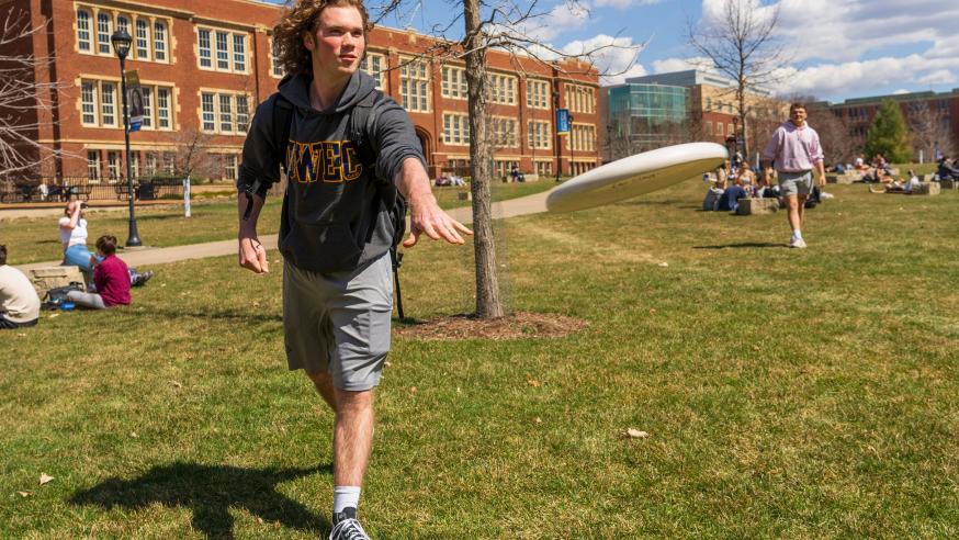students playing frisbee outside