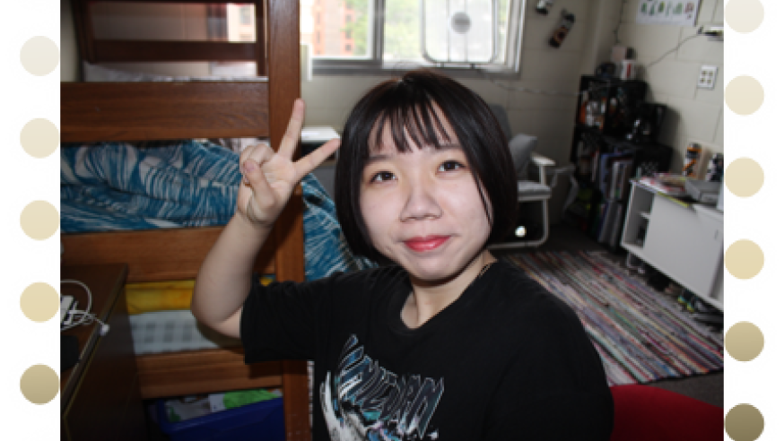Chinese student holding up peace sign in her dorm