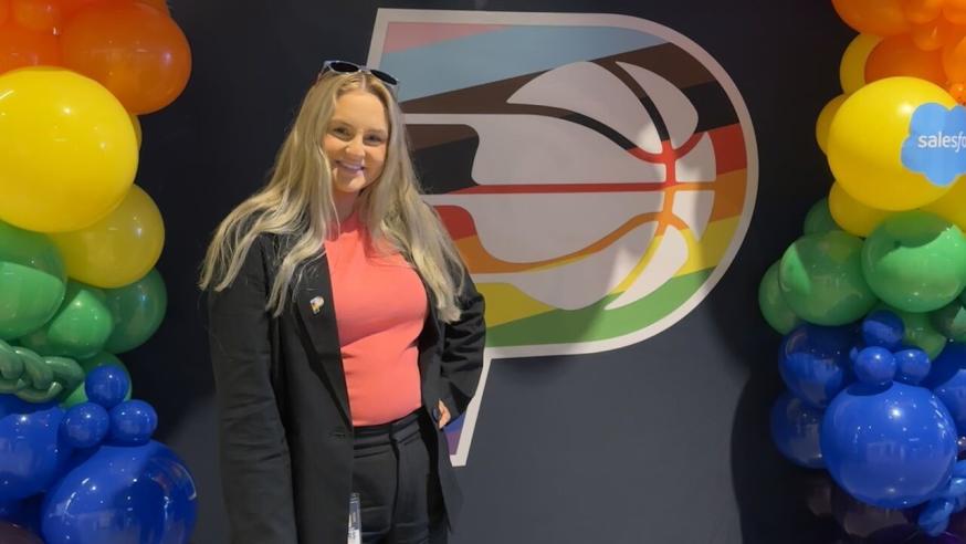 Chayse Earney, marketing alumni and Digital Partnerships Coordinator for Pacers Sports, standing in front of Pacers Sign.