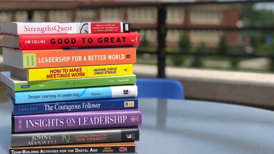 Leadership books stacked on a table