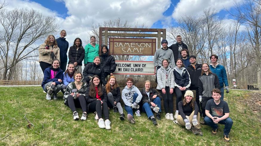 Students posing in front of a welcome sign for UW-Eau Claire