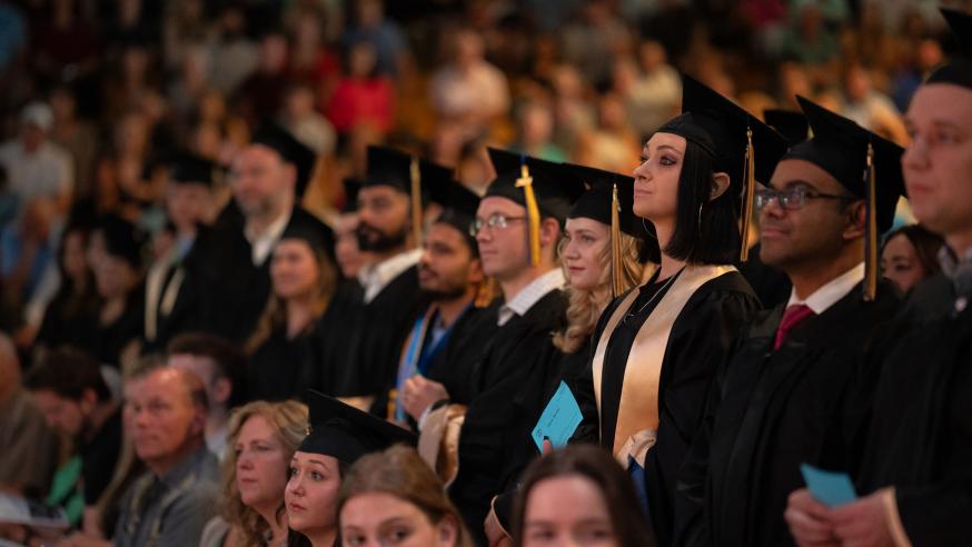 Graduates stand ready to receive their diploma 