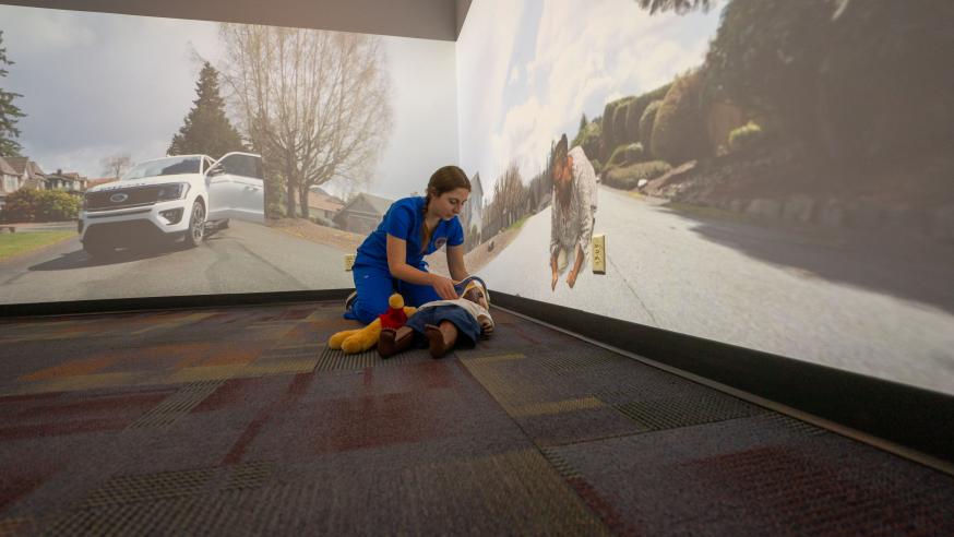 nursing student using new simulation room with child mannequin