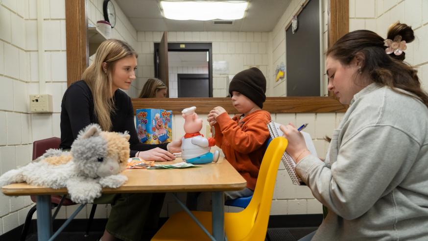 Two students work with a child at the Human Development Center on campus.