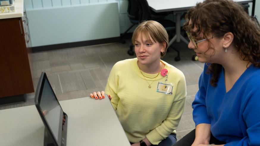 A clinician and participant look at a tablet together.