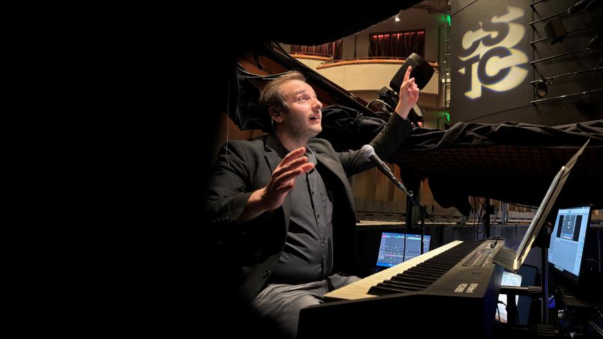 Miles Plant conducting in sound booth of a production