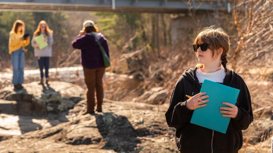 Students take notes outdoors during a geology class