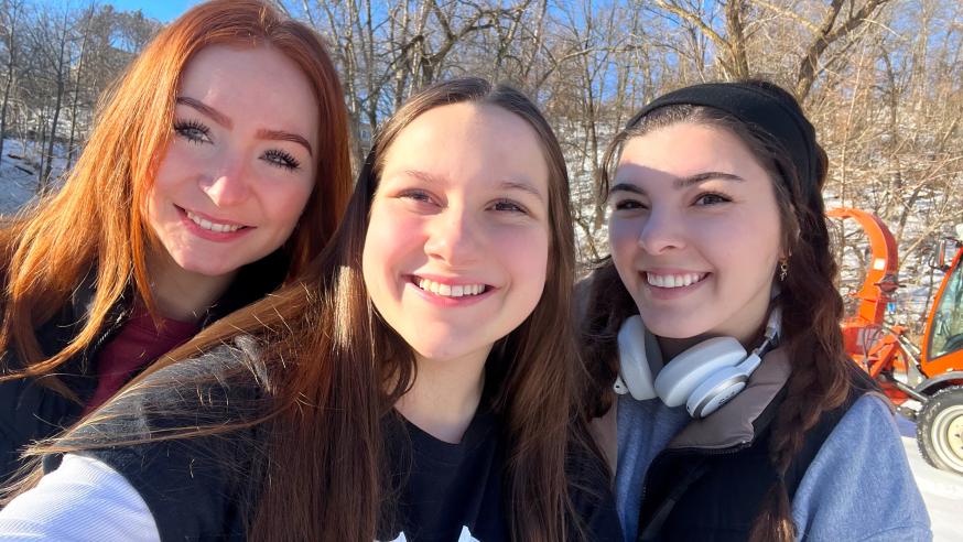 Three members of Greek Life smiling at the camera