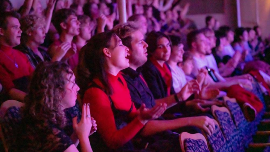 Audience members cheering on performers