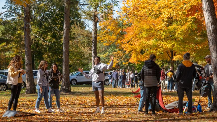 Students laugh and play games amongst the fall trees in Carson Park during Homecoming.