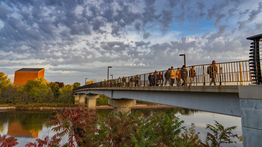 Students walk across the bridge on a beautiful Fall day.