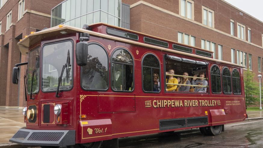 Students wave to the camera while aboard the Eau Claire trolley.