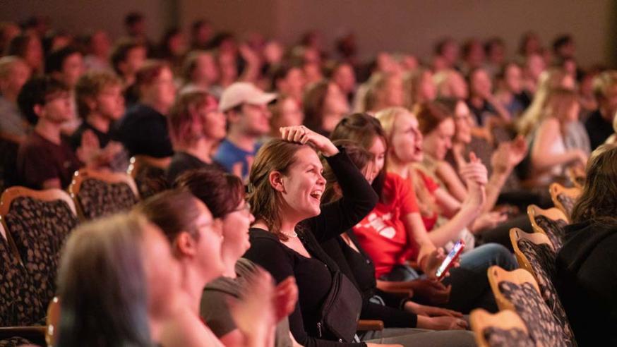 Large group of event attendees laugh and smile during Varsity Night Live.