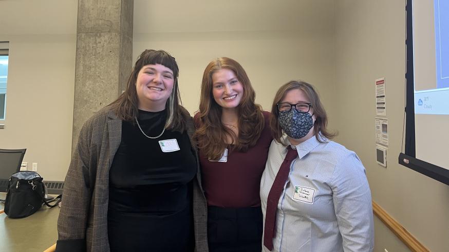 UWEC students Lee Rutzinski and Bree Muske and Writing Center assistant director Aubrie Warner grouped and smiling after a presentation 