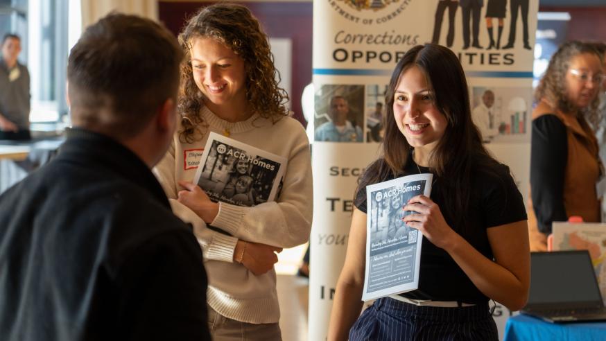 two students at Health Career Fair talking to table reps