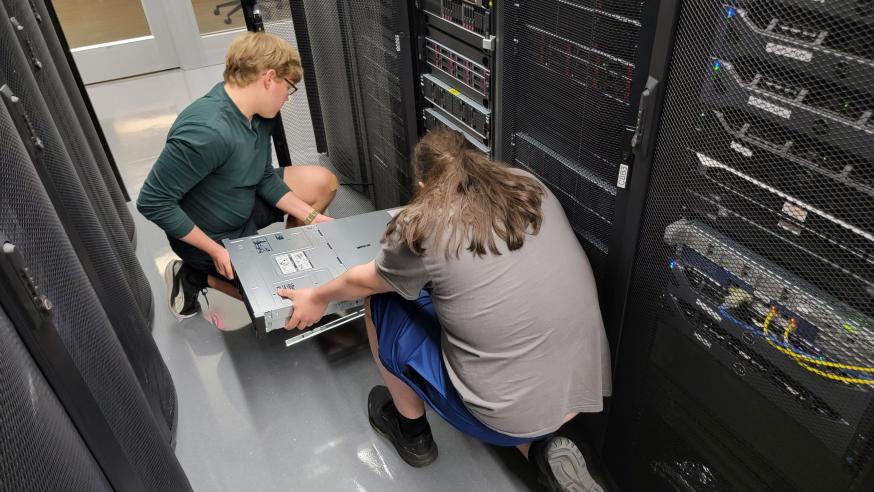 Students install hardware for a new NVIDIA H100 server at the Blugold Center for High Performance Computing in May 2025