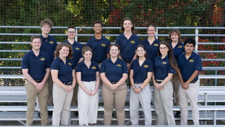 Kevin Miro and the rest of the BMB student staff pose on the bleachers in uniform