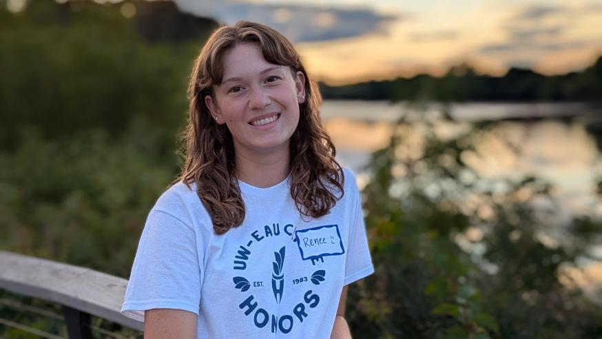 Honors student Renee Sandoval leans on a UWEC handrail overlooking the river at sunset 