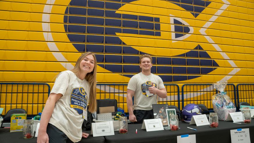 Two students post for a photo while working at a physical education conference at the Sonnentag