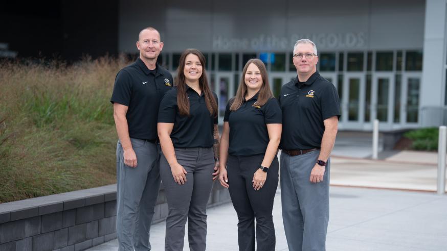 A group of four athletic training staff at UWEC smile for the camera.