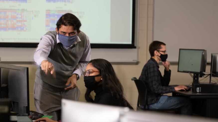 Dr. Gomes works with student in computer lab